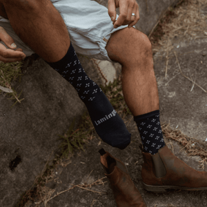 Man wearing Lamington merino crew socks in navy with light blue cross pattern made in New Zealand.