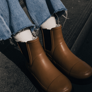 Merino Wool Crew Socks worn with brown rubber boots and distressed denim, showcasing a stylish outdoor look.