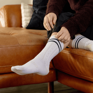 Woman wearing Lamington merino crew socks in cream with black stripes made in New Zealand.
