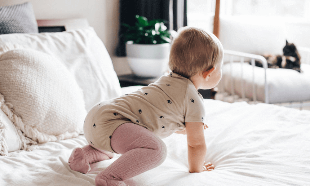 Baby crawling on a bed wearing comfortable Merino Wool Tights 