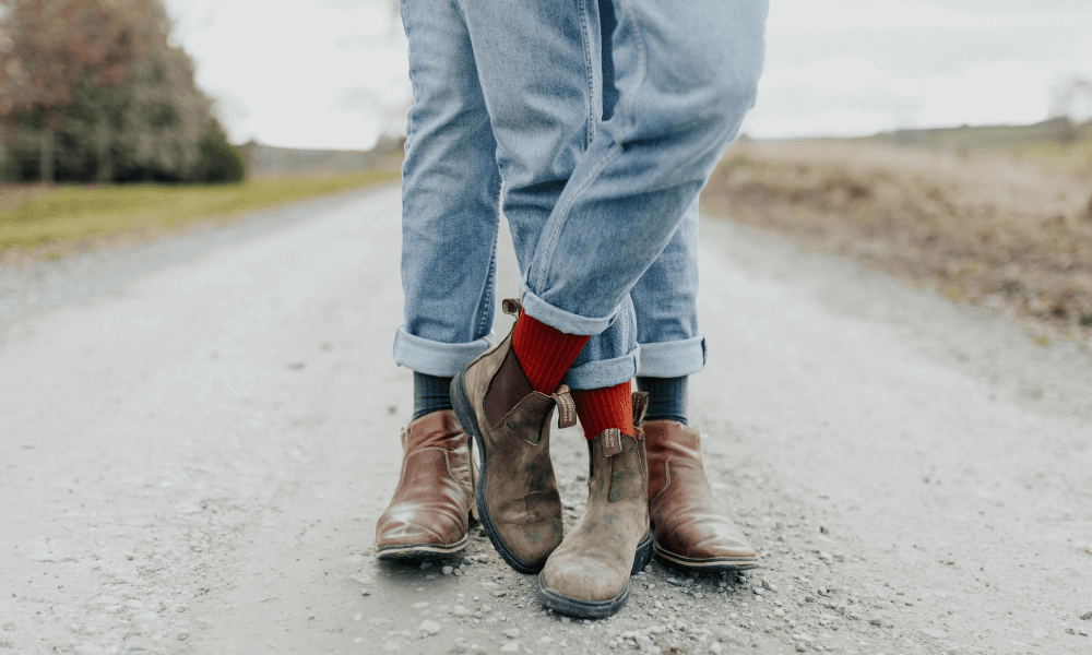 Couple wearing merino socks standing on a country road, showcasing that merino socks make the BEST gifts!