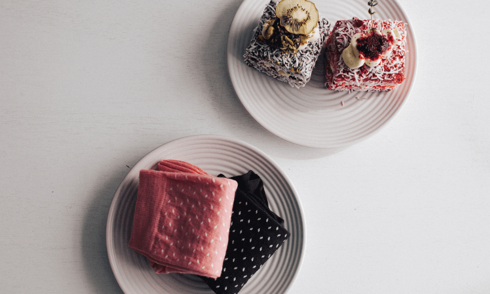 Two plates featuring colorful lamingtons, highlighting the story behind the dessert in 'why we are called lamington'.