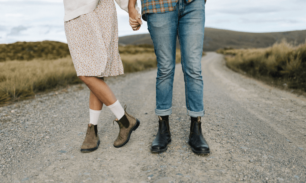 Couple holding hands on a country road, showcasing corporate gifted socks 
