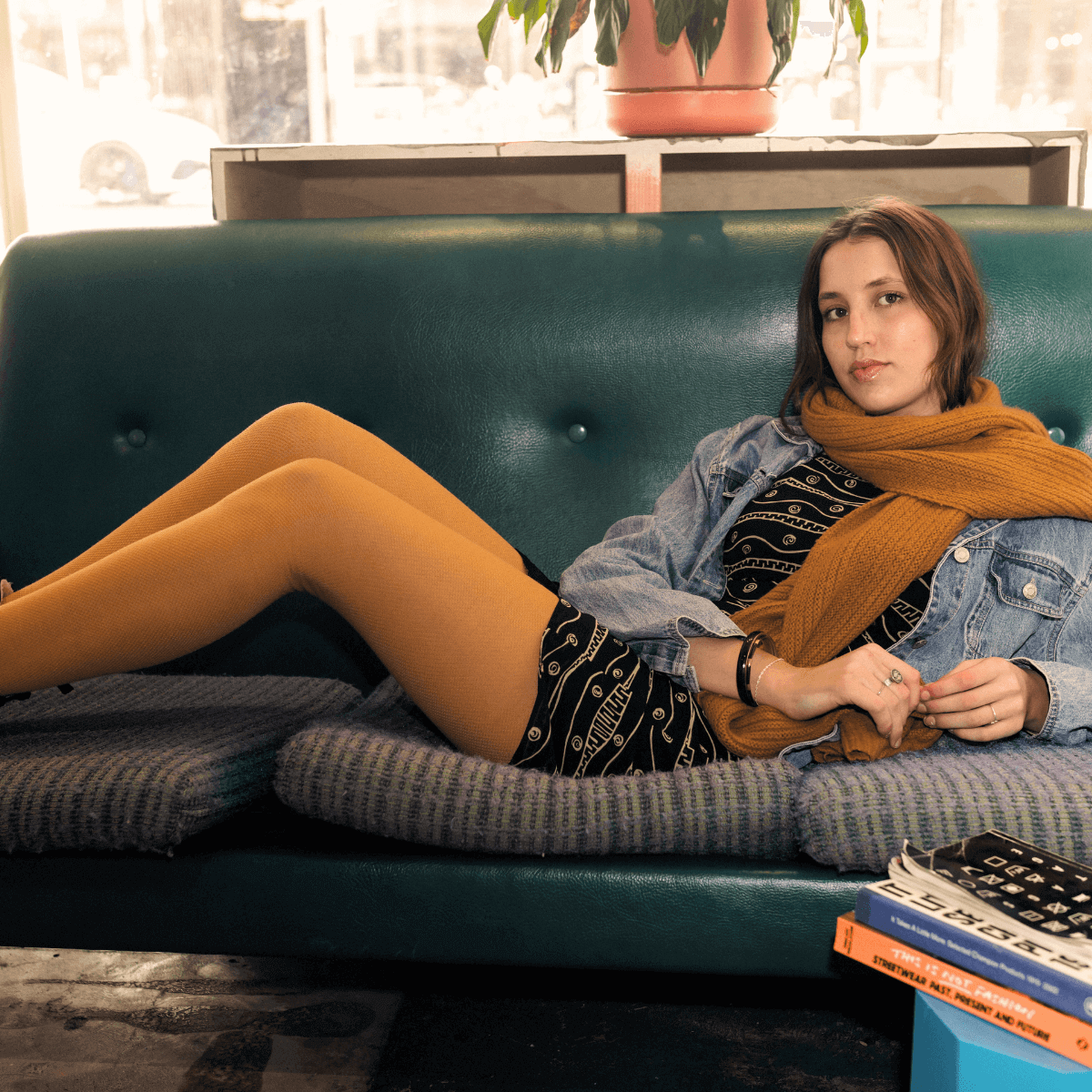 Merino Wool Textured Knit Tights in mustard color worn by a woman sitting on a couch, cozy and stylish outfit.